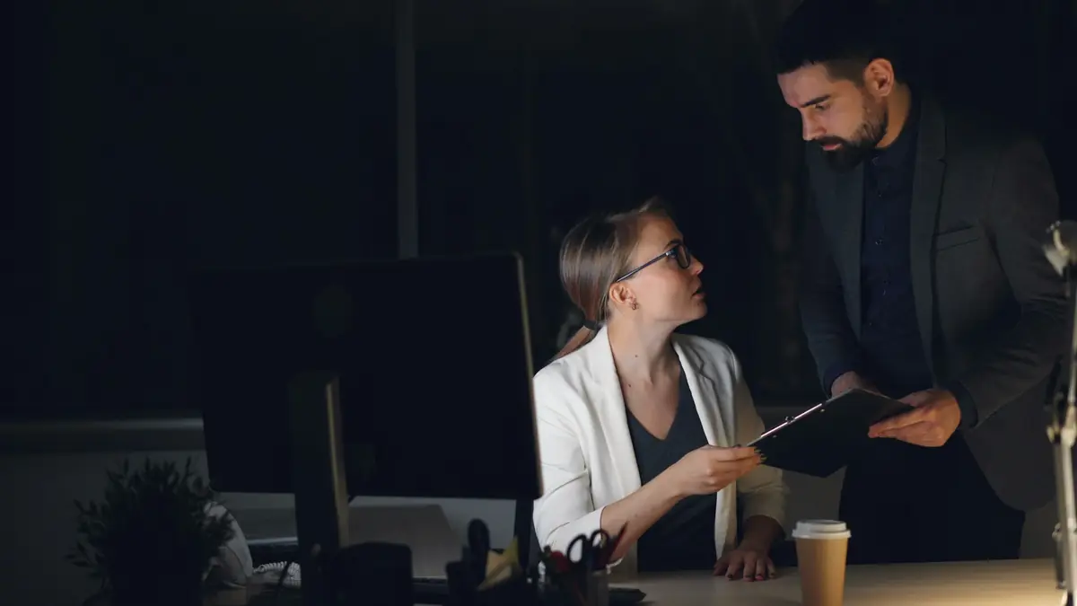 Late at night, a senior colleague stands over an associate’s desk and goes through the work with her.